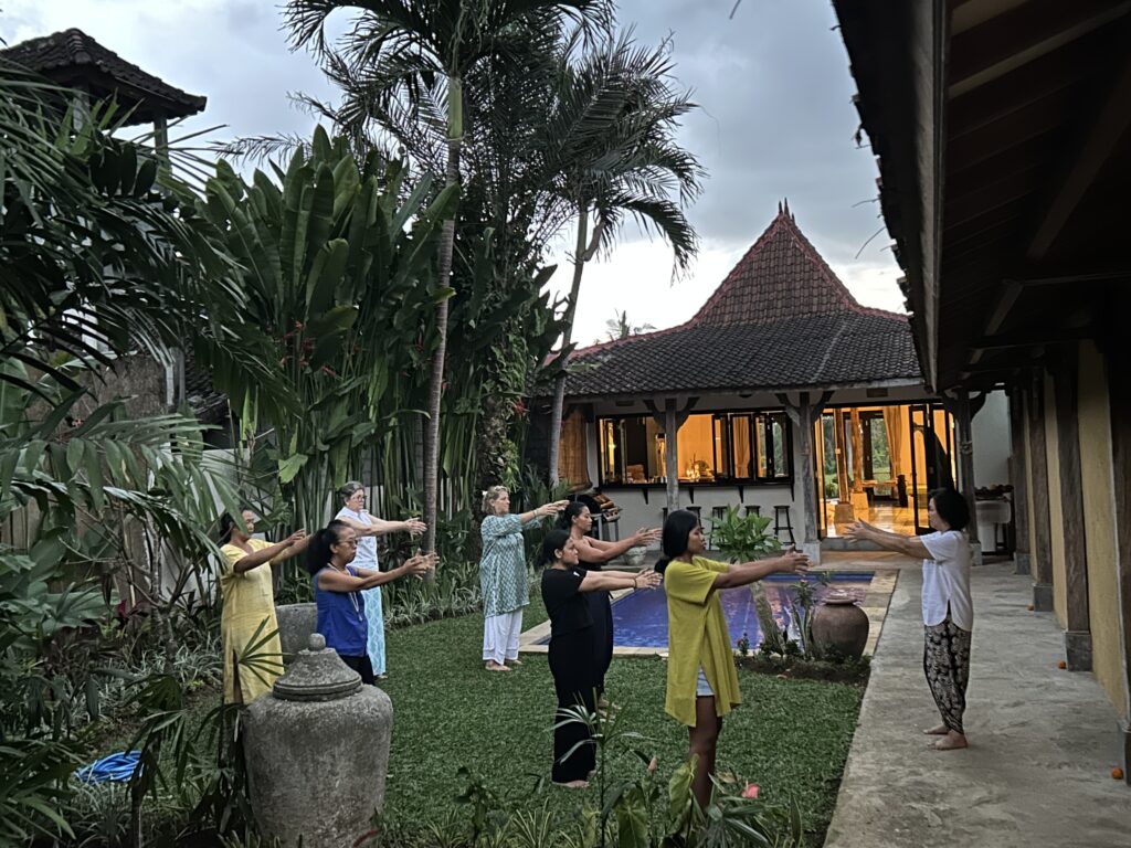 Wellness Community Doing Qigong Practice in Serene Ubud with Pool and Joglo house background